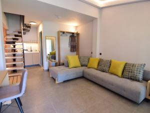 尼基季Aloe The Green Suites - Nikiti Halkidiki的客厅配有灰色的沙发和黄色的枕头。