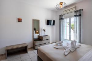 帕罗斯岛Villa Kalamies 2的白色卧室配有床和镜子