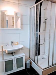 库克斯港Dat lütte Strandhuus的一间带玻璃淋浴和水槽的浴室