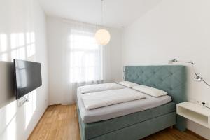 博尔扎诺Apartments Leonardo的一间卧室配有蓝色的沙发和一台电视