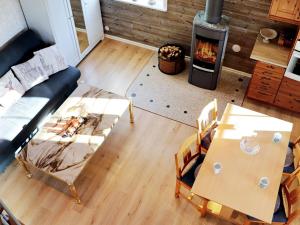 Vittsjö6 person holiday home in VITTSJ的客厅配有沙发、两张桌子和一个壁炉