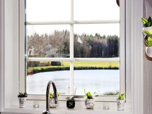 Vittsjö6 person holiday home in VITTSJ的湖景厨房窗户