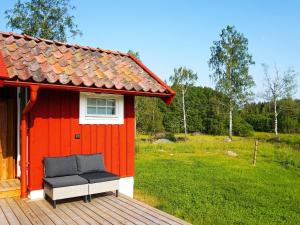 Mellösa5 person holiday home in Mell sa的甲板上设有长凳的红色房子