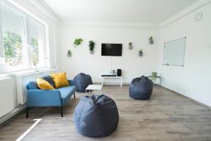 蒂萨菲赖德Chili House Tiszafüred的客厅配有2把蓝色椅子和电视