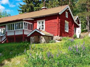 Åshammar7 person holiday home in J RBO的一座红房子,位于一座小山上,花色紫色