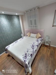 比奥格勒·纳·莫鲁Villa Nina的一间卧室配有一张带紫色和白色棉被的床