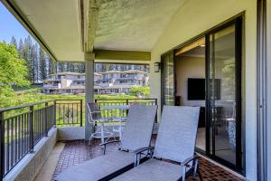 卡哈纳Kapalua Golf Villas 16V3的阳台的门廊配有三把椅子和一张桌子