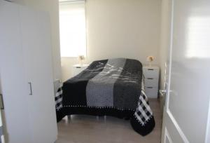赞德沃特Casa 1-2-3的一间卧室配有一张带黑白毯子的床