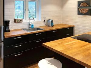 加普腾4 person holiday home in GARPHYTTAN的厨房配有水槽和木制台面