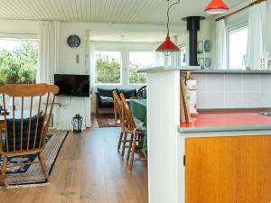 灵克宾6 person holiday home in Ringk bing的厨房以及带桌椅的起居室。