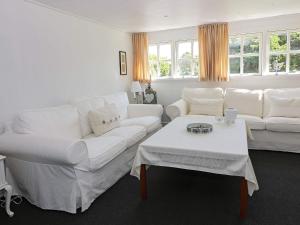 Haslevgårde4 person holiday home in Hadsund的客厅配有2张白色沙发和1张桌子
