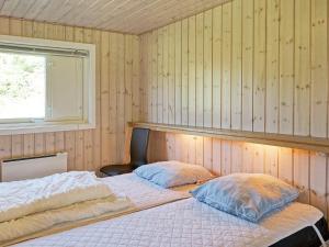 维斯特索马肯12 person holiday home in Aakirkeby的一间卧室设有两张床和窗户。