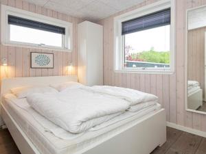 埃贝尔托夫特Holiday home Ebeltoft XXI的带2扇窗户的客房内的一张白色床