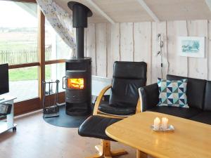 布罗艾厄7 person holiday home in Broager的客厅设有壁炉、桌子和椅子