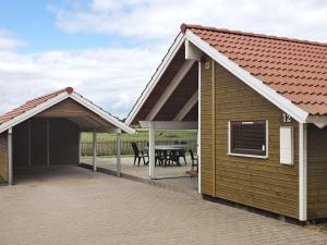 布罗艾厄7 person holiday home in Broager的房屋设有带顶棚和桌子的庭院