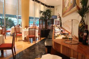 墨西哥城斯卡拉麦格纳酒店 的一间带桌椅和柜台的餐厅