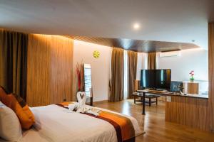 坤敬曼特拉瓦雷酒店的配有一张床和一台平面电视的酒店客房