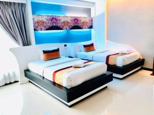 坤敬曼特拉瓦雷酒店的一间卧室,配有两张床