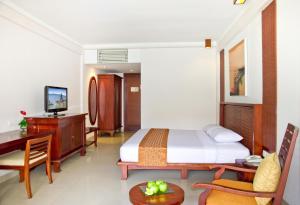 库塔拉尼酒店及水疗中心的配有一张床和一张书桌的酒店客房