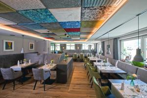 奥伯林塔尔的里德图因霍夫酒店的餐厅设有桌椅和色彩缤纷的天花板。