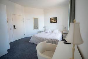 伦讷Det Gamle Posthus的白色卧室配有床和椅子