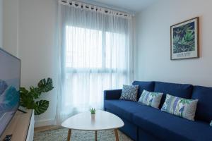 大加那利岛拉斯帕尔马斯Eli Canteras-Parking-Airco by CanariasGetaway的客厅配有一张蓝色的沙发,配有一张桌子