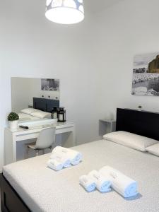 那不勒斯ChilometroZERO luxury apartment的一间设有两张床、桌子和毛巾的房间