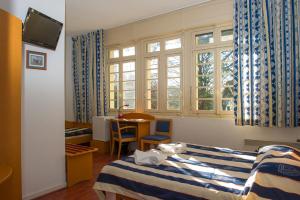 比亚里茨VTF Le Domaine de Françon的酒店客房设有两张床和窗户。