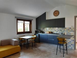 西斯蒂亚纳Appartamento SG的厨房配有蓝色橱柜和桌椅