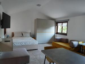 西斯蒂亚纳Appartamento SG的一间卧室配有一张床、一张沙发和一张桌子