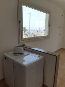 阿沃拉Fronte Mare的带窗户的客房内的洗衣机