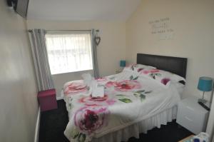 布莱克浦Devon Guest House的一间卧室,床上有粉红色的鲜花