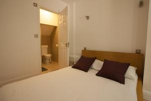 伦敦Tooting Rooms by DC London Rooms的卧室配有一张带两个枕头的大白色床
