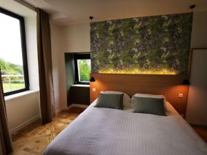 孔卡尔诺Domaine de Stang Bihan的卧室配有一张带两个枕头的大白色床