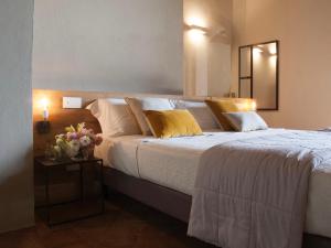蒙特普齐亚诺科尔特瑟格拉特旅馆的一间卧室配有一张带白色床单和黄色枕头的大床。