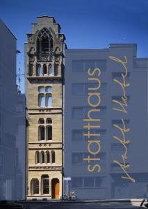 科隆statthaus - statt hotel的一座高大的建筑,旁边有一个标志