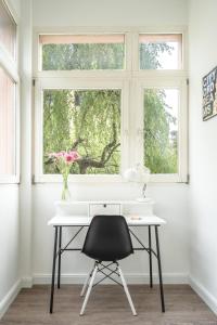 因斯布鲁克InnsbruckHomes at Botanical Garden的窗前带黑椅的白色书桌