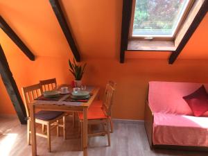 斯莫尔德兹诺Agroturystyka Pod Dębami w Klukach的橙色墙壁的房间里摆放着桌椅