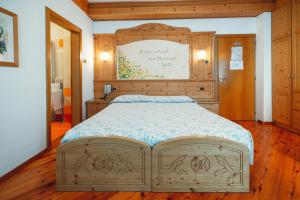 马洛斯科Hotel Bel Soggiorno的一间卧室配有一张大床和木制床头板