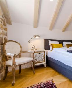 杜布罗夫尼克Villa Monte Santo的一间卧室配有一张床、一把椅子和一盏灯