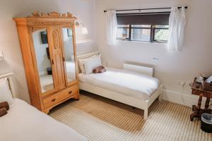 克劳奇河畔伯纳姆Creeksea Place Barns的一间小卧室,配有两张床和镜子