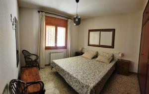 CastelloteCasa Rural Tobal的一间卧室配有一张床、镜子和窗户