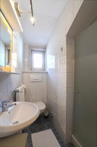 海利根布卢特兰德豪斯艾尔喷罗斯 - 弗瑞恩德米兹尔皮克勒旅馆的白色的浴室设有水槽和卫生间。