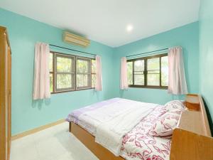 邦涛海滩Village House Wat 1的一间蓝色卧室,配有床和2个窗户