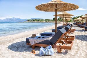 多西亚The Marble Resort的海滩上的一组椅子和遮阳伞