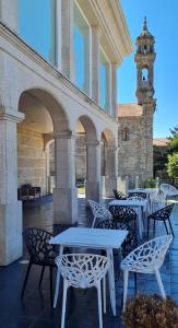 琼克伊拉-德伊斯巴达尼Casa Grand Galicia的一个带桌椅的庭院和钟楼