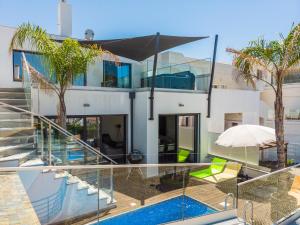 阿尔沃尔Villa Miragem Alvor的一座带游泳池和玻璃墙的房屋