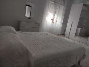 那不勒斯La quiete del Vesuvio的卧室配有白色的床和窗户。