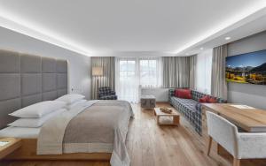基茨比厄尔Schwarzer Adler Kitzbühel - Adults Only的一间卧室配有一张大床和一张沙发