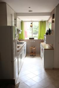 奥比丹Appart Bin Elouidane的一间厨房,配有白色家电和绿色窗帘